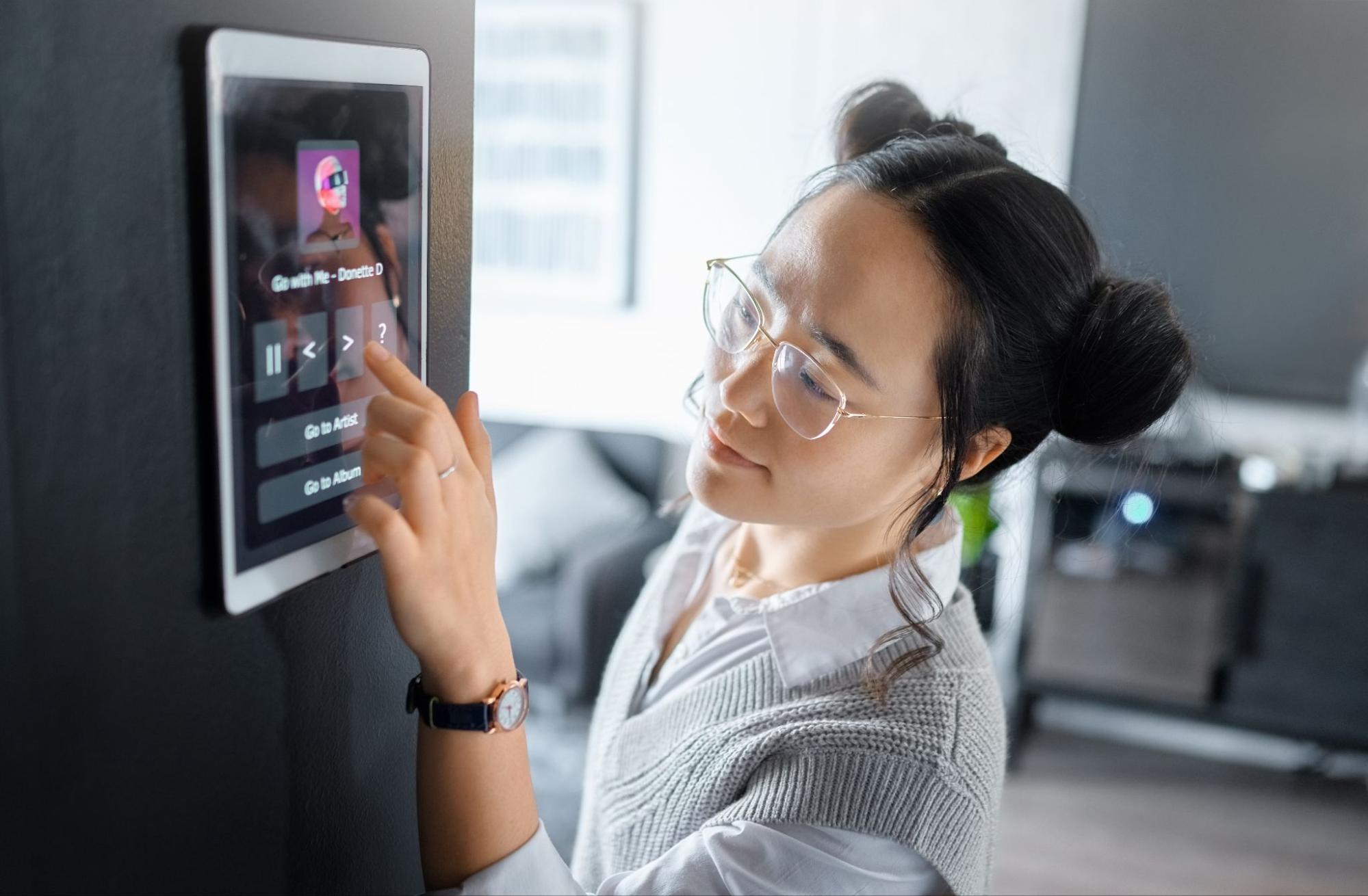 A pharmacist wearing glasses is looking at a touch screen while practicing cybersecurity